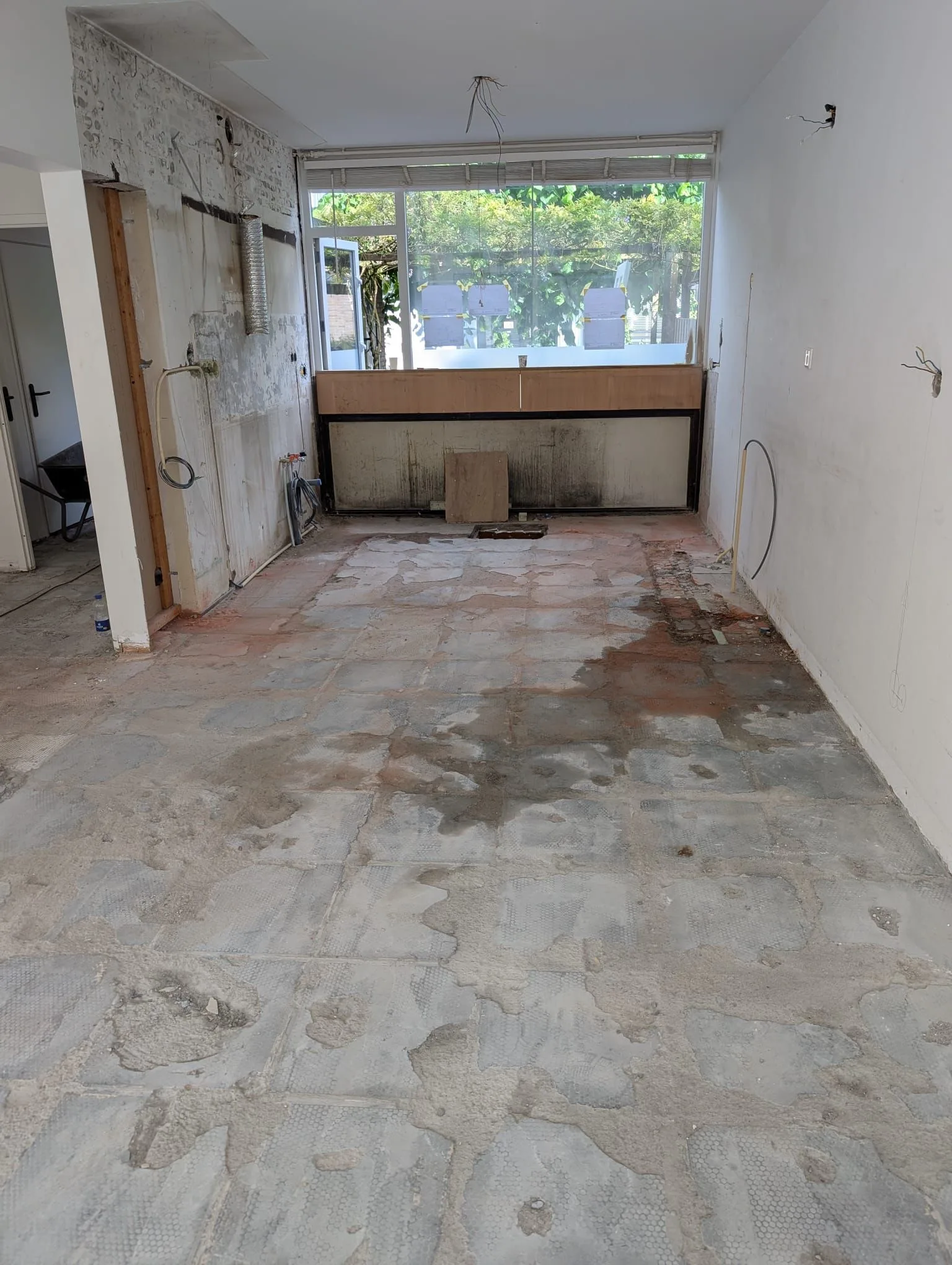 Oude, sterk beschadigde ondervloer voor de renovatie