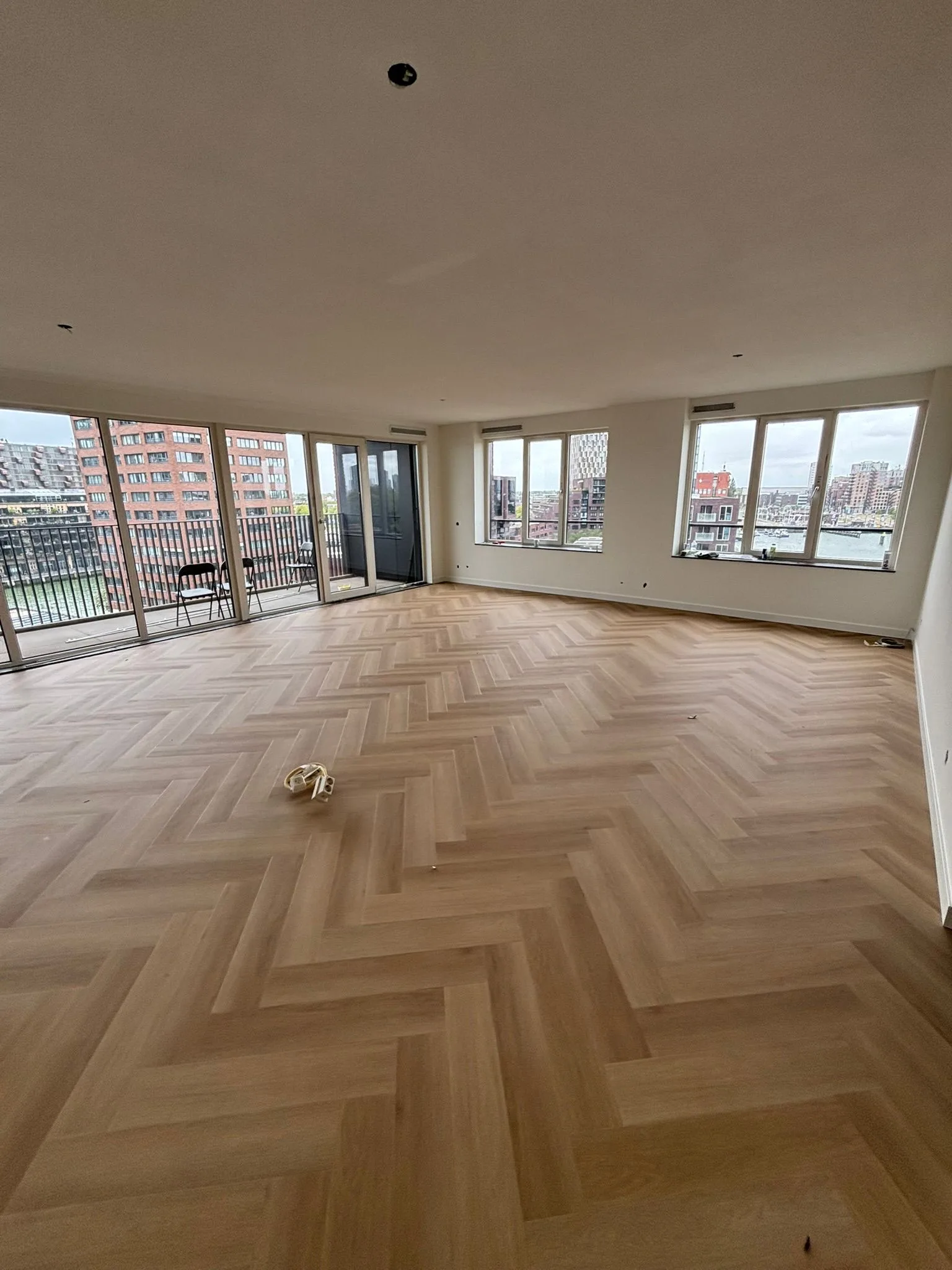 Visgraatvloer in een appartement met uitzicht over de haven