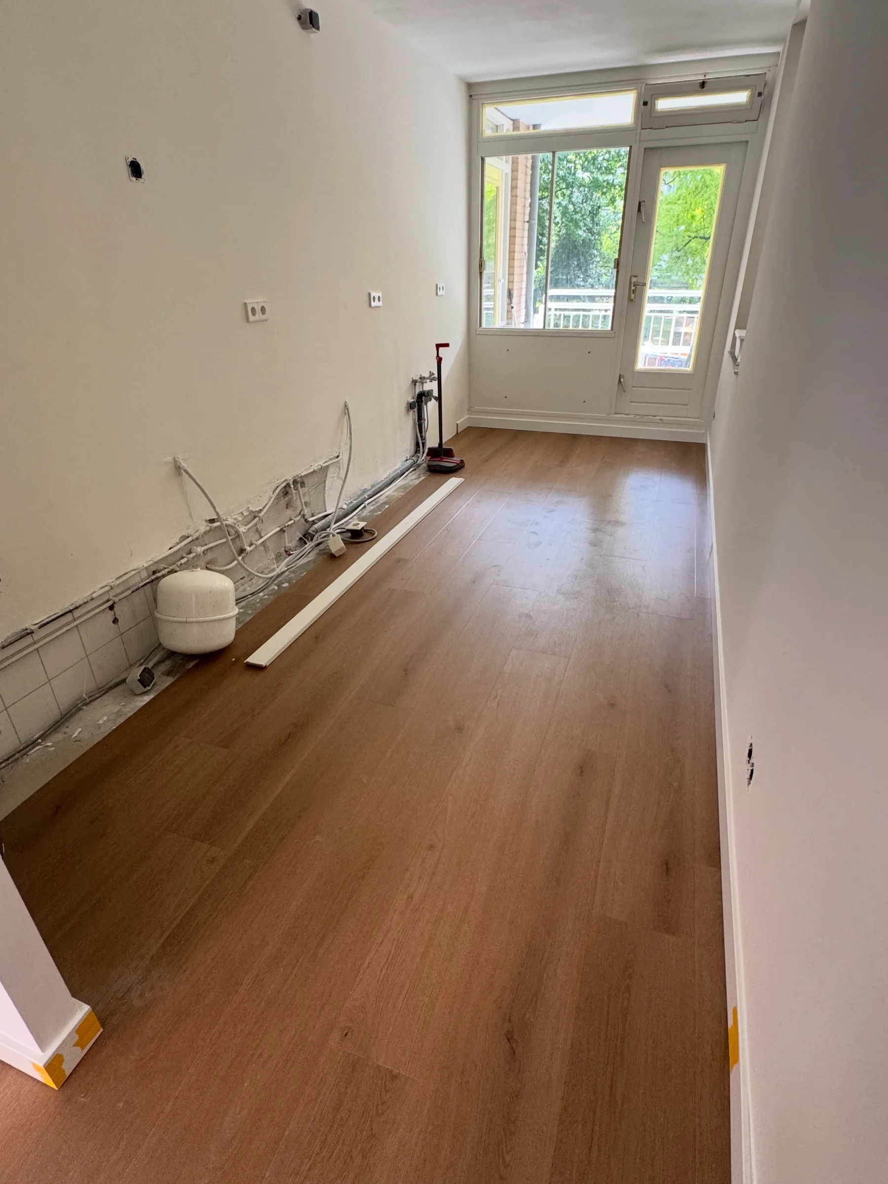 Rechte strook PVC vloer in een slaapkamer met leidingwerk in de hoek