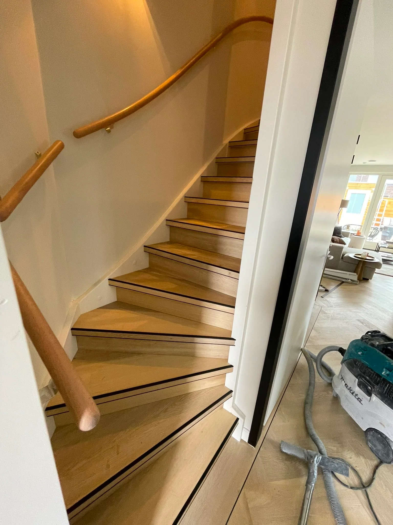 Trap met PVC treden in eikenlook en een houten leuning