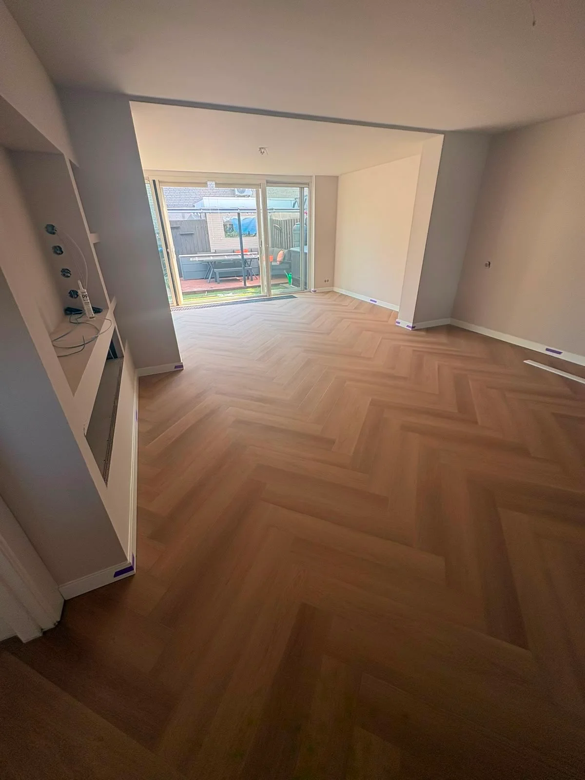 Visgraat PVC vloer in een woonkamer met schuifpui naar de tuin