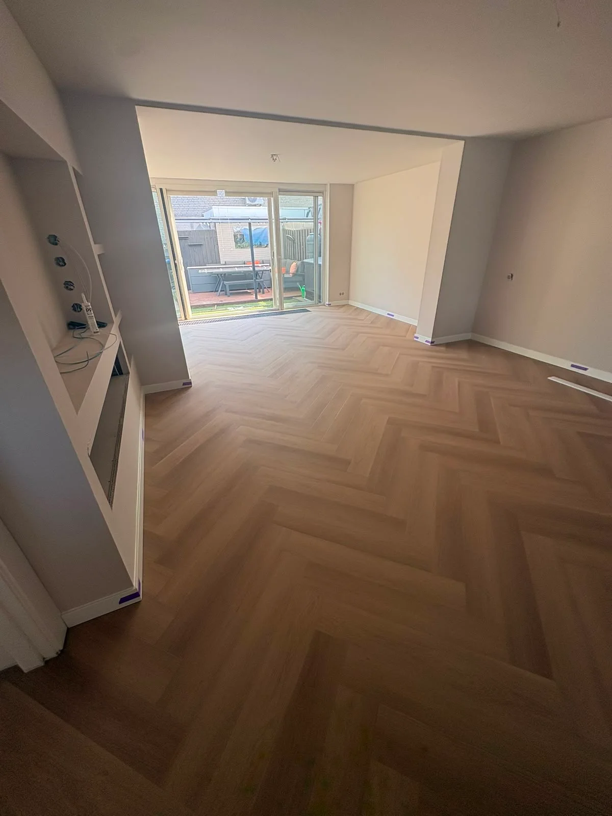 Walvisgraatvloer in een woonkamer met openslaande tuindeuren